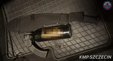 Na gumowej macie leży nóż w pochwie, gaz pieprzowy w kaburze oraz kilka drobnych metalowych przedmiotów, oznaczone znakiem KMP Szczecin.